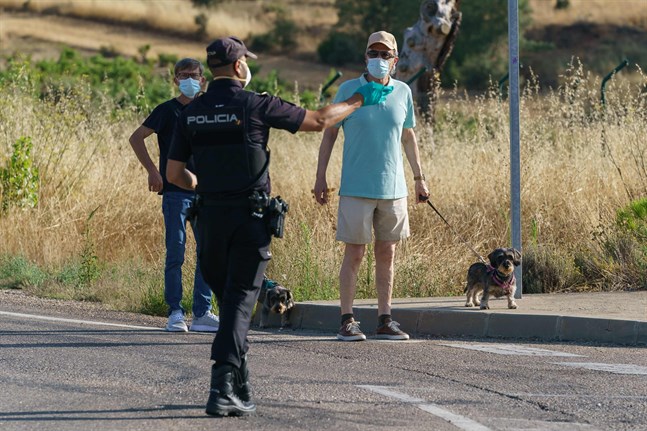 Myndigheterna i Spanien reagerade för sent men nu tas krisen på allvar och alla hjälps åt, skriver Ellinor Granholm om hur man hanterat coronapandemin i Spanien. På bilden pratar en polis med två män vid en vägspärr i Aranda de Duero nära Burgos, den 7 augusti. Då infördes en två veckors lockdown för att försöka begränsa spridningen av covid-19 i regionen.