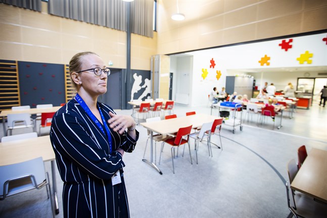 Miia Raunio ståendes i det rum som vanligtvis är gymnastiksalen, i bakgrunden syns den skiljevägg mellan matsalen och gymnastiksalen som nu är borttagen.