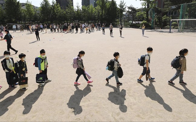 Skolelever med munskydd i Seoul när de fick gå tillbaka till skolan i slutet av maj.