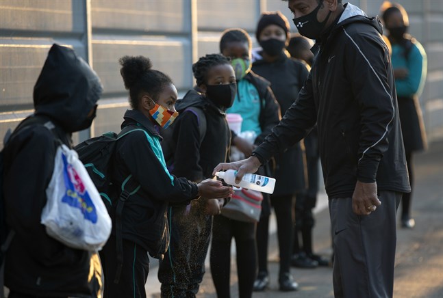 Elever spritar sina händer i samband med att de deras skola återöppnar i Johannesburg i Sydafrika.