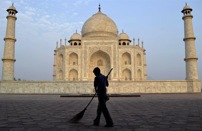 En arbetare sopar framför Taj Mahal. På måndagen öppnar Indiens populäraste turistattraktion för besökare, efter att ha hållit stängt på grund av covid-19. Arkivbild.