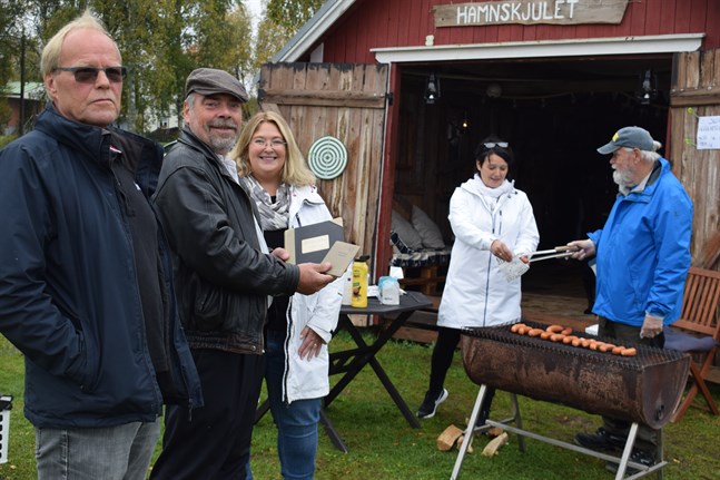 Styrelseledamöterna Tom Gädda och Johan Strömberg och ordförande Sara Åhman. I bakgrunden grillar styrelseledamoten Anja Backman och Nisse Karlström korv.
