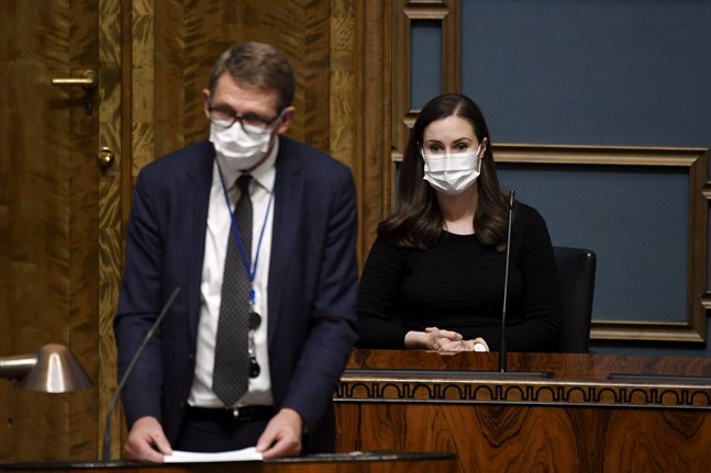 Finansminister Matti Vanhanen (C, i förgrunden) och statsminister Sanna Marin (SDP) försvarade regeringens politik mot oppositionens kritik på onsdagen.