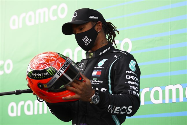 Lewis Hamilton med en av Michael Schumachers tidigare racinghjälmar.