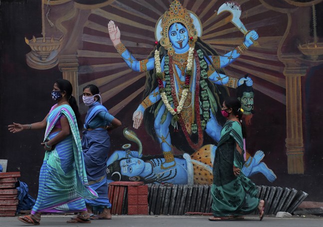 Indiska kvinnor passerar ett altare till gudinnan Durga i Hyderabad. Antalet coronasmittade i Indien har passerat sju miljoner, när hinduernas festivalsäsong just ska börja.