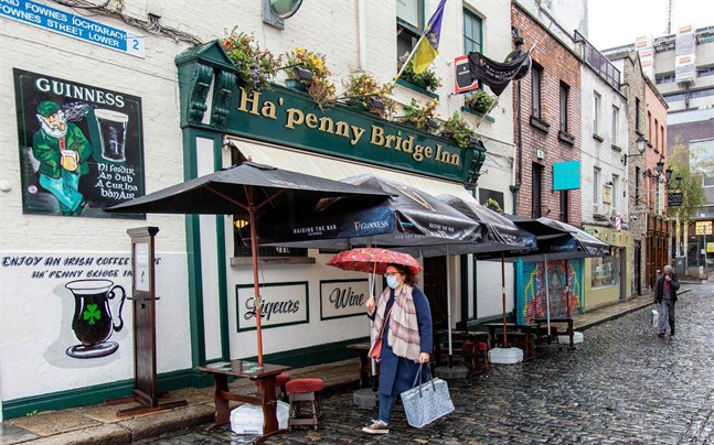 En kvinna passerar en nedstängd pub i Irlands huvudstad Dublin på måndagen.