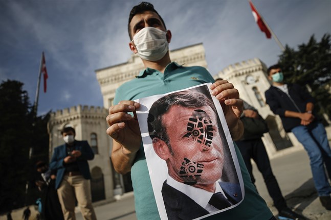 En ung man protesterar mot Frankrikes president Emmanuel Macron vid en demonstration i Istanbul.