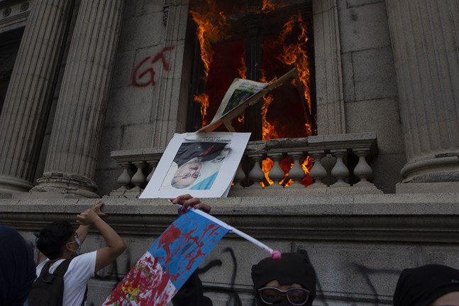 Arga demonstranter satte eld på kongressbyggnaden i Guatemala City på lördagen.