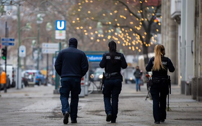 Ordningsvakter patrullerar längs Kurfuerstendamm i Berlin för att kontrollera att alla restriktioner följs.