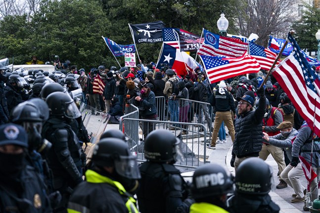 Anhängare till president Donald Trump möts av kravallklädd polis utanför Kapitolium den 6 januari, strax innan stormningen av kongressen.