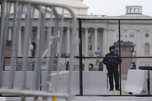 En polisman vaktar ett avspärrat Capitolium i Washington DC, efter stormningen förra veckan. Nödläge har utlysts i staden inför Joe Bidens installation den 20 januari.