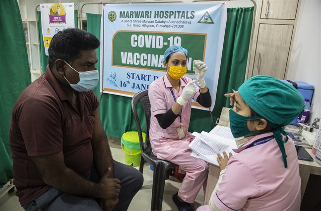 En sjuksköterska förbereder en vaccindos på ett sjukhus i Gauhati, Indien. Planen är att vaccinera 300 miljoner människor till juli 2021.