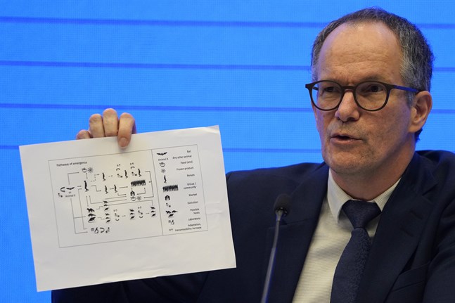 Peter Ben Embarek från Världshälsoorganisationen WHO håller upp en bild som visar olika vägar som viruset spridits.