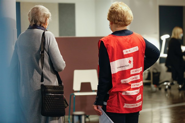 Utbildade frivilliga från Röda Korset ger råd åt dem som kommer för att vaccinera sig.