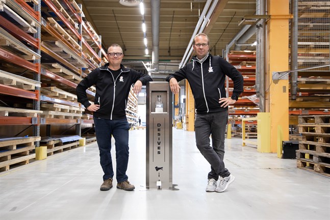 Jani Poikkimäki och Tom Bergström visar upp Veslatecs automat för handsprit.