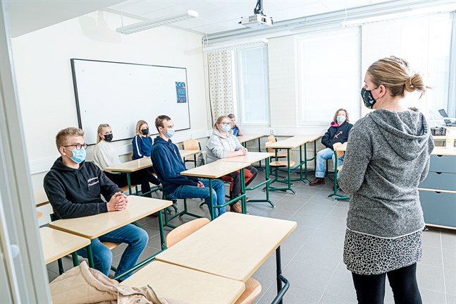 Fritidskoordinator Hanna Aarnio diskuterar med en grupp ungdomar om vad ungdomsfullmäktige sysslar med.