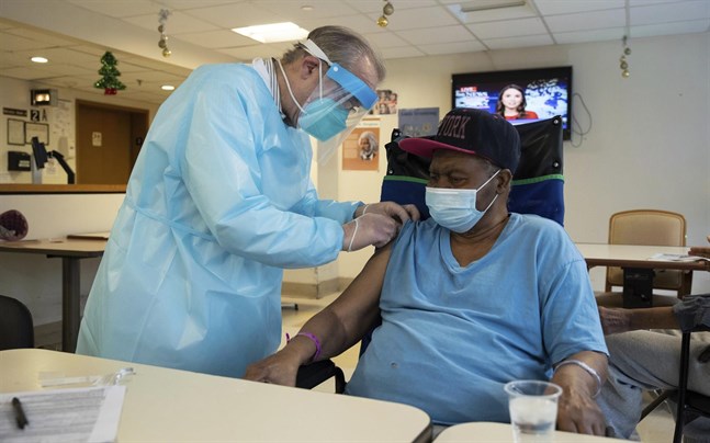 En person vid ett äldreboende i Harlem i New York får en vaccinspruta. Bild från januari.