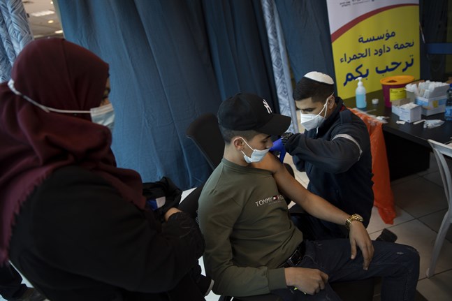 Ett israeliskt vårdlag ger vaccin till palestinier vid kontrollstationen Qalandia mellan Ramallah och Jerusalem.