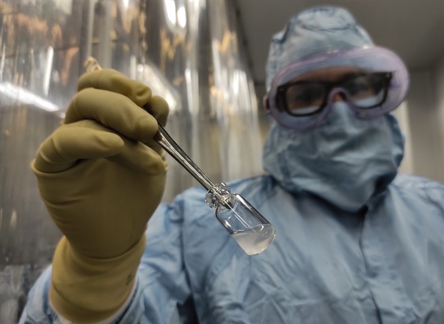 En anställd vid Finlay-institutets förpackningsanläggning i Havanna visar upp en dos av "Soberana 2", en av Kubas fyra vaccinkandidater.