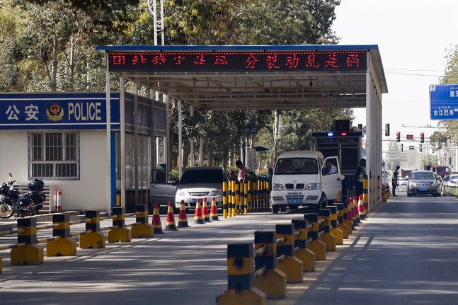 Uigurer får sina fordon kontrollerade vid en poliskontrollplats i Hotan i Xinjiang. Arkivbild.