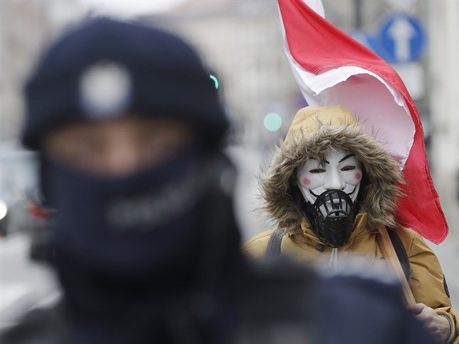 En man protesterar mot restriktionerna i Polen. Arkivbild.