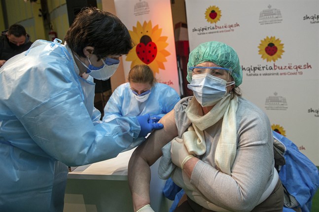 En albansk sköterska vaccinerar en läkare från grannlandet Kosovo med Astra Zenecas coronavaccin.