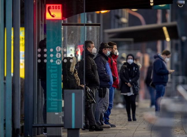 Tyskar i munskydd väntar på tunnelbanan i Frankfurt am Main.