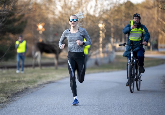 Sandra Eriksson under de avslutande hundra metrarna på sitt lopp på fem kilometer. I bakgrunden syns älgen som gjorde deltagarna sällskap.