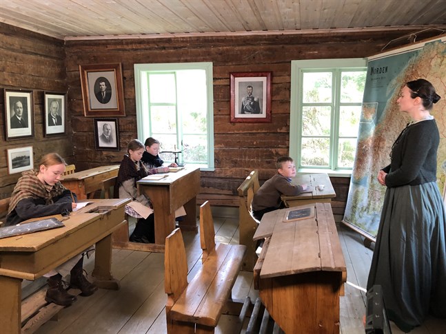 Så här kunde det se ut i skolan för hundra år sedan. Scenen är från skolstugan på museiområdet i Öjskogsparken och från inspelningen av julkalendern "Tidernas jul". Skolbarnen spelar av från vänster Tuva Sundell, Tova Klingenberg, Tindra Sandvik och Sigge Wilson. Lärarinnan spelas av Carla Fri.
