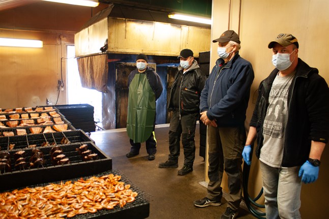 Stefan Smedman, Thomas Sund, Ole Lundberg och Mats Eriksson betraktar dagens arbete. Den nyrökta fisken ska snart leta sig bort från rökeriet till kunderna.