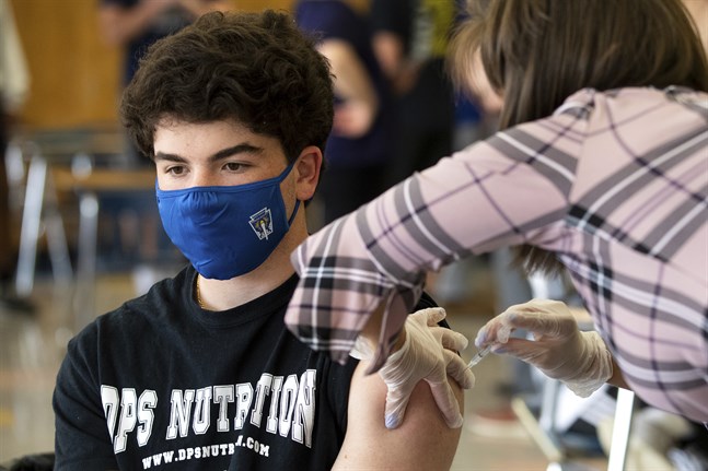 Gymnasieeleven AJ Tomassoni får en vaccinspruta mot covid-19 på Valley View High School i Archbald, i delstaten Pennsylvania, den 30 april.