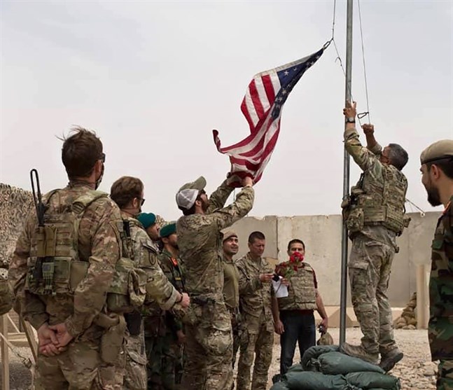 Den amerikanska flaggan halas i samband med att den amerikanska armén lämnar över en militärbas till den afghanska armén i provinsen Helmand, söndagen den 2 maj.