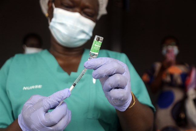 En sjuksköterska i Nigeria förbereder dos coronavaccin. WHO varnar nu för att den afrikanska kontinenten riskerar att drabbas av en ny covidvåg på grund av försenade leveranser och problem med att få ut de doser man har.