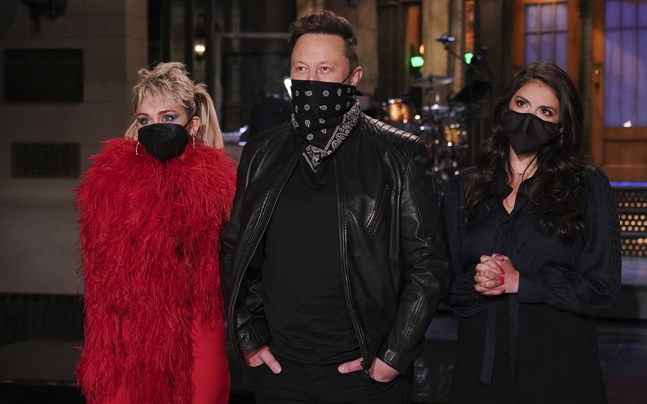 Elon Musk poserar med artisten Miley Cyrus (vänster) och komikern Cecily Strong (höger) inför helgens "Saturday Night Live".
