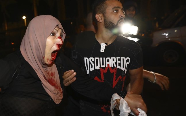 En skadad palestinsk demonstrant tas om hand i området Sheik Jarrah i östra Jerusalem.