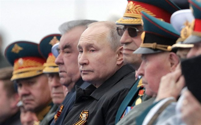 Rysslands president Vladimir Putin har sällskap av ett antal dignitärer då han ser på paraden på Röda torget i Moskva.