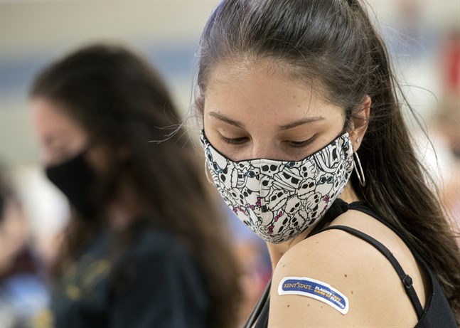 Regan Raeth, student vid Kent State University, tittar på sitt plåster efter att ha vaccinerats i Ohio. Bild från i april.