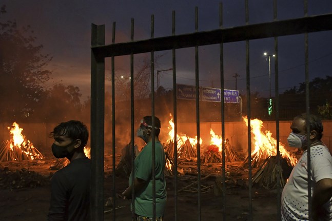 Många indier som avlidit med covid-19 dumpas i Indiens stora vattendrag. Här säger människor farväl till sina anhöriga vid ett provisoriskt krematorium i huvudstaden New Delhi den 6 maj. Arkivbild.
