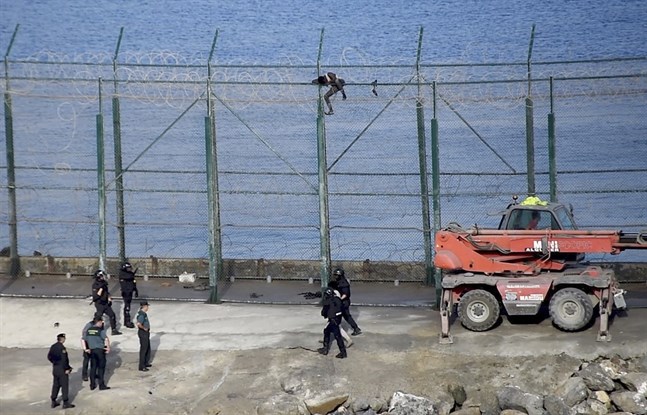 Många migranter försöker ta sig in i Ceuta genom att klättra över stängslet vid gränsen. Andra simmar. Arkivbild.