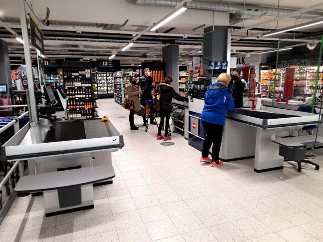 Kassakön ringlade lång då den nya matbutiken öppnade i före detta Halpa-Hallihuset på torsdagen. Karin Westergård betalar sitt inköp i kassan.