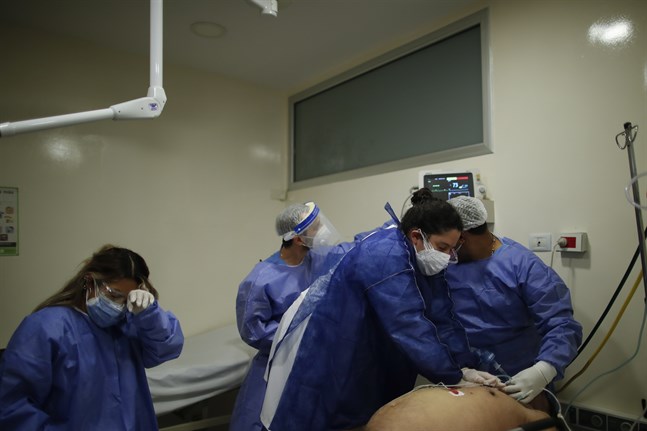 En läkare utför hjärt-lungräddning på en patient med covid-19 som fått en hjärtattack på ett sjukhus i Lomas de Zamora i Argentina.