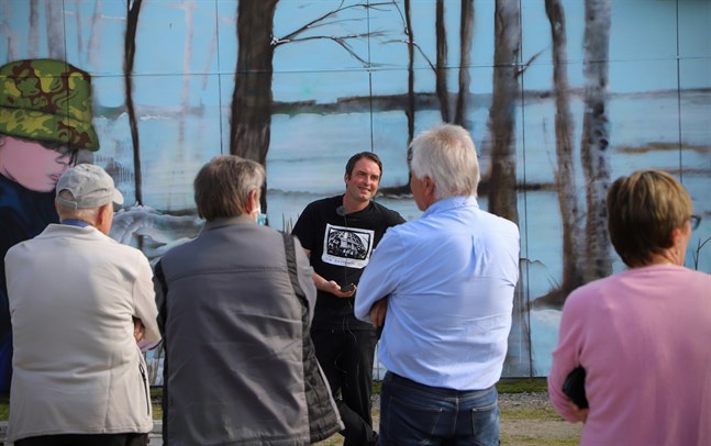 "Det jag gillar med offentlig konst är att man får så mycket respons och att människor engagerar sig i den", säger Jon Gredmark. Här inviger han sin senaste väggmålning tillsammans med Petalaxborna.