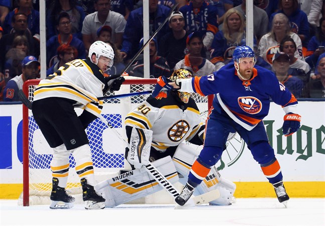 New York Islanders Leo Komarov (till höger) skymmer sikten för Bostonkeepern Tuukka Rask samtidigt som han tappat klubban under "blusen" på motståndaren Mike Reilly.