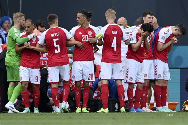 De danska spelarna bildade en mur runt Christian Eriksen när han fick behandling på planen i Köpenhamn.