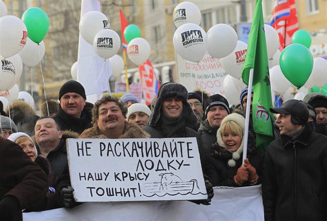 Författaren Dmitrij Bykov håller en skylt under en protest i Moskva 2012. Bredvid står oppositionsledaren Aleksej Navalnyj.