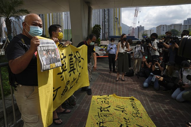 Demonstranter protesterar på lördagen utanför domstolen i Hongkong, till stöd för två chefer vid den prodemokratiska tidningen Apple Daily som ställs inför rädda.