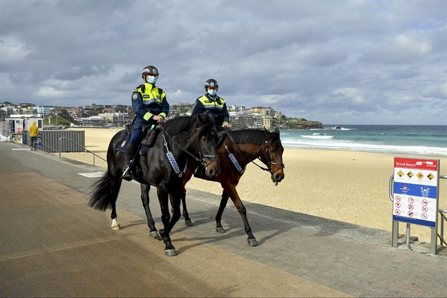Poliser patrullerar Bondi Beach i Sydney för att se till att alla följer nedstängningen.
