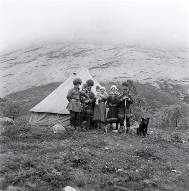 "Oförmögna, oordningssamma och primitiva var omdömen som användes om samerna i utredningarna som föregick tvångsförflyttningarna på 1920-talet", skriver Söderholm i sin essä. På bilden står den svenska familjen Labba vid sitt sommartält i Sørfold, Nordland, Norge. Vilket år bilden är tagen anges inte.