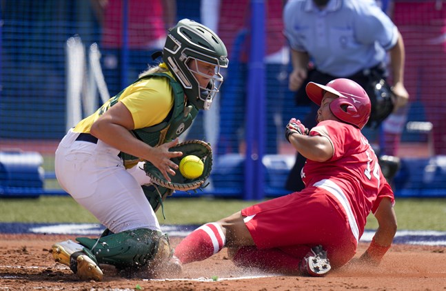 Japans Minori Naito, till höger, och Australiens Taylah Tsitsikronis i OS-premiären i softball i Fukushima.