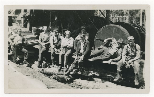 Edvin Eklund från Purmo, mitt i bild med mörk tröja, vis en "steam donkey", en ångdriven vinsch som användes för att dra ut timmer ur skogen. (1929-1935)